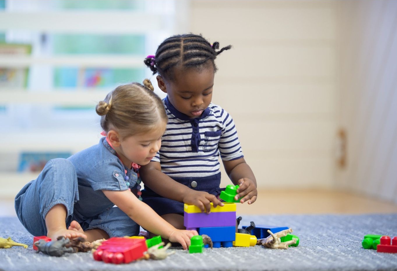 Two children building together with colorful blocks